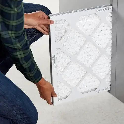 Person installing Six pack MERV 8 furnace air filters fit standard 16x20x1 slots, trapping dust, pollen and lint to improve indoor air quality.