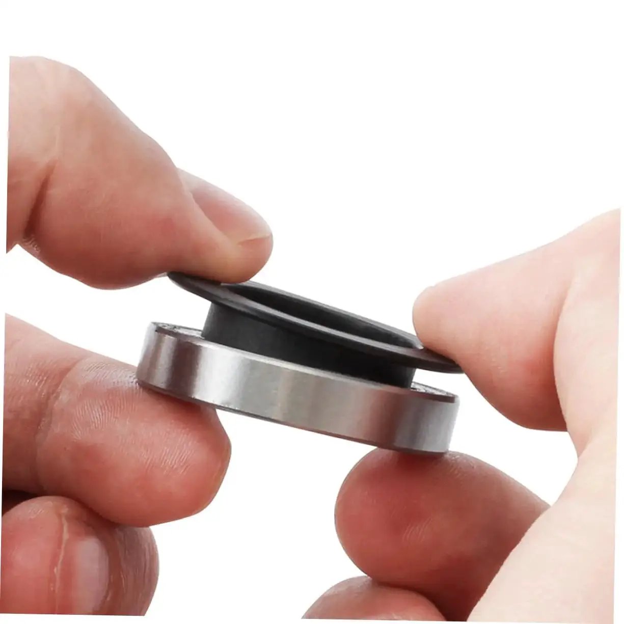 Close-up of hands holding Two Pack Black Axle Protection Covers for Bike Bearings Dust Covers, showing installation.