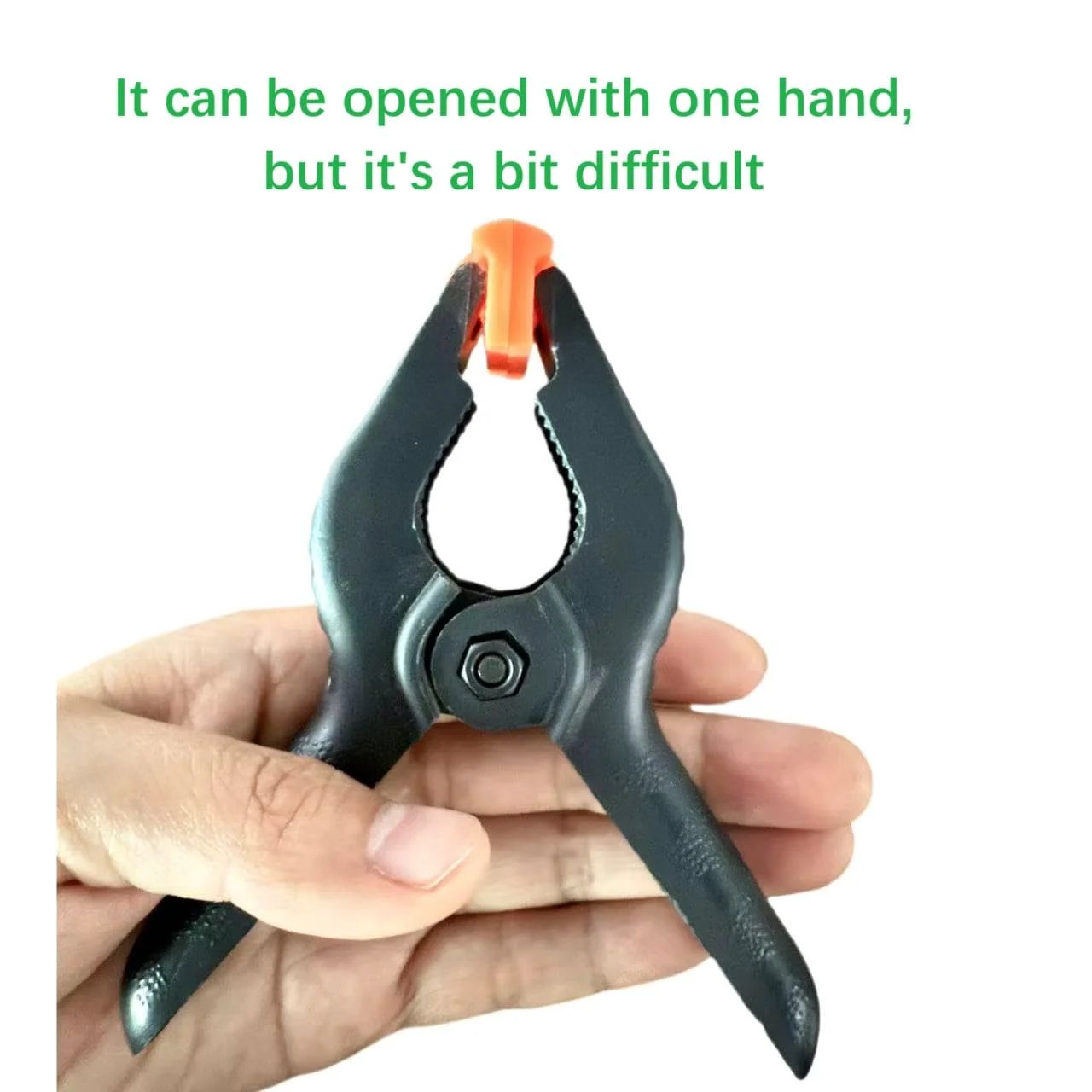 Close-up of a single 4.5 inch heavy duty plastic spring clamp in a hand, showcasing its durable nylon construction and anti-slip handles.