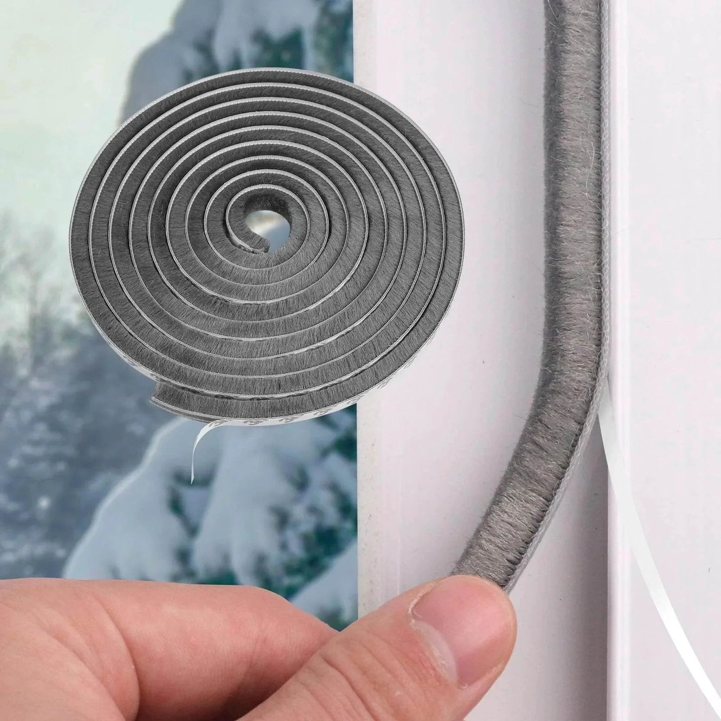 Close-up of 40FT Weather Stripping Door Seal with nylon brush being applied to window, showing self-adhesive backing for anti-draft insulation.