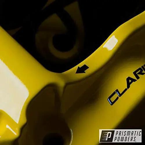 Close-up of yellow metal part coated with Clear Vision Powder Coat Top Coat For Automotive Wheels High Gloss UV Resistant