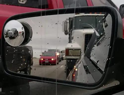 Blind Spot Mirror 2 Inch Round HD Glass Frameless Convex Rear View Mirror Pack Of 2 For Side Mirrors No-Fuss 360 Degree Adjustable Clear Wide Angle Easy Install mounted on side mirror showing rear view with rain on glass.