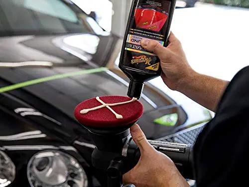 Person applying Meguiar's Ultimate Compound for Cars That Removes Oxidation Swirl Marks Water Spots And Scratches On Clear Coat with an applicator