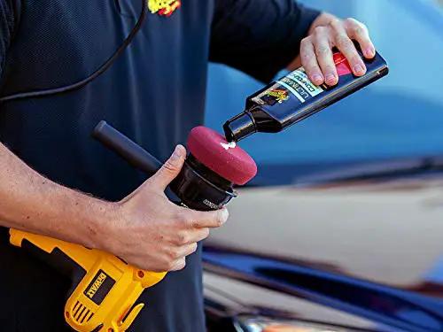 Close-up of a person applying Meguiar's Ultimate Compound For Cars That Removes Oxidation Swirl Marks Water Spots And Scratches On Clear Coat.