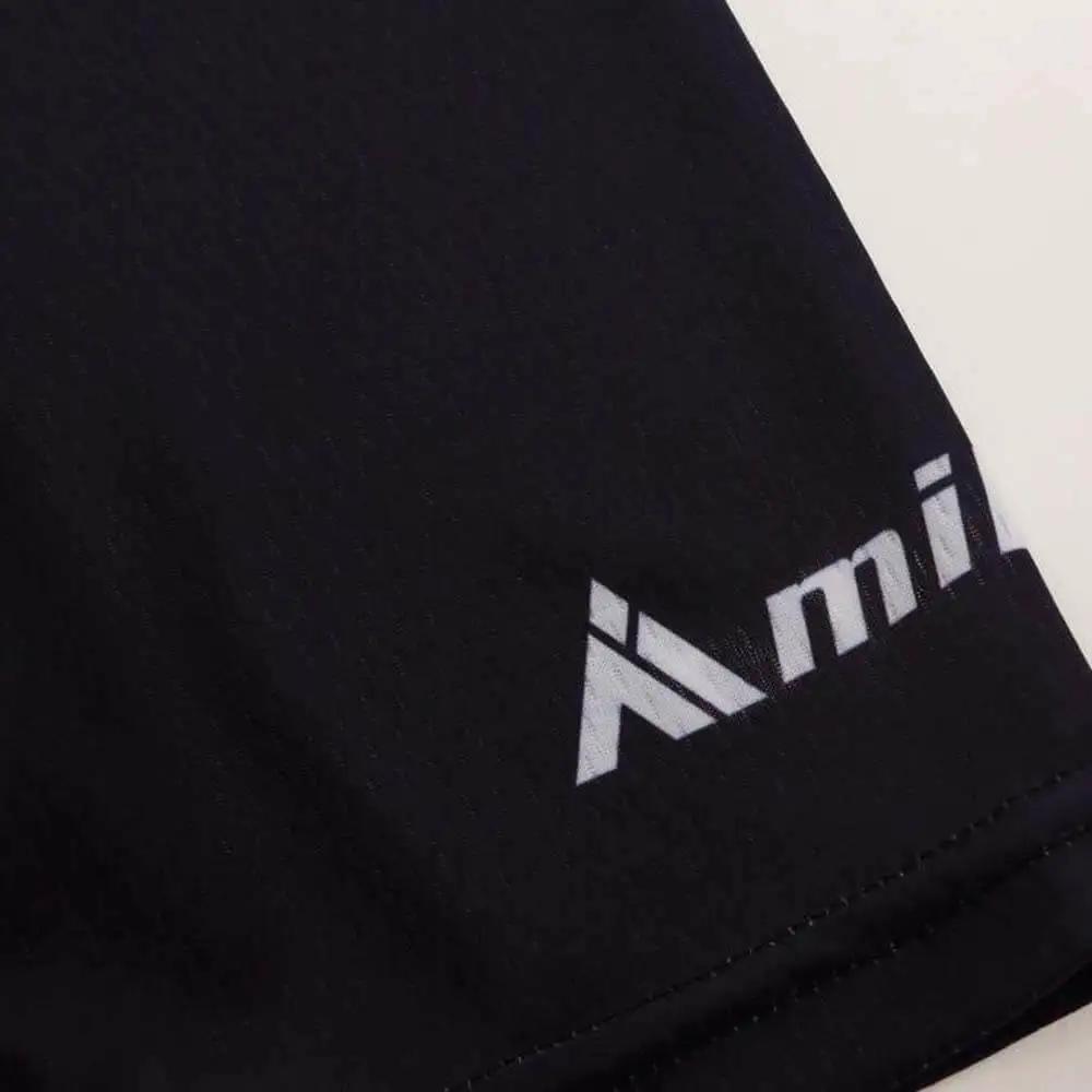 Close-up of a black fabric with white logo in the corner.