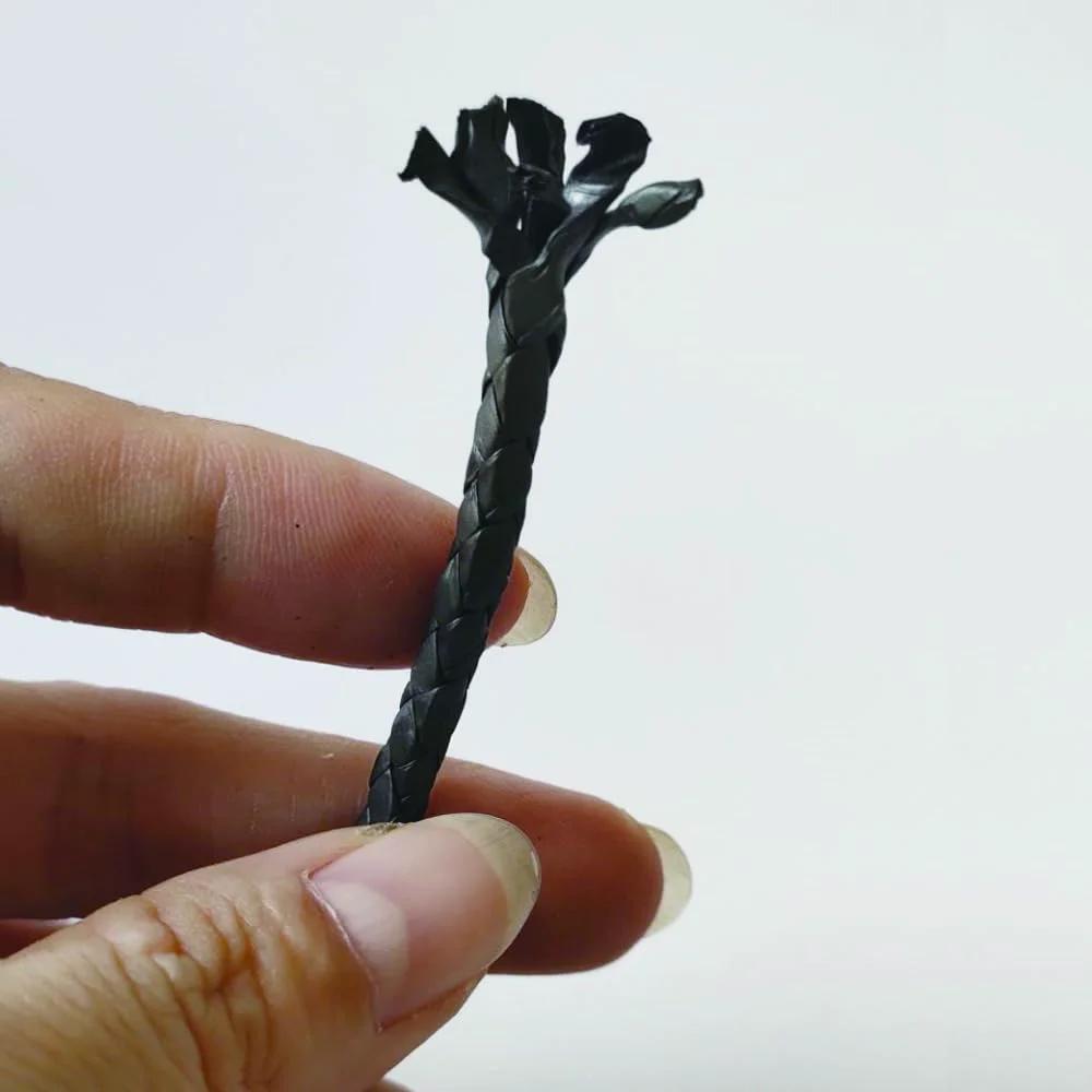 Graphitized Expanded PTFE Graphite Braided Compression Packing One Eighth Inch By One Eighth Inch Ten Feet Long, held in hand.