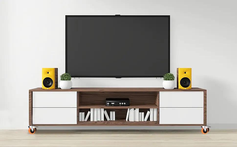 Modern entertainment center with TV, speakers, and books on a stand, showcasing home decor styling.