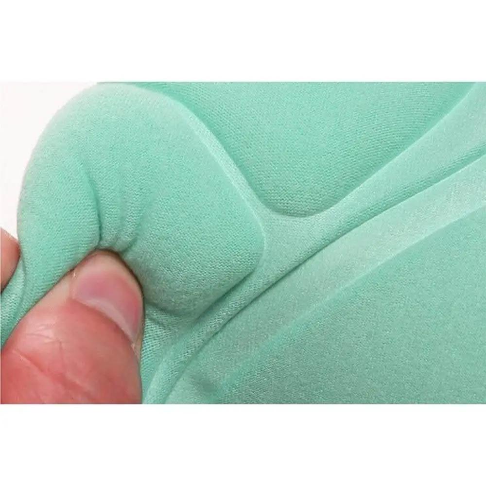 Close-up of a hand touching soft mint green fabric with padding, demonstrating texture and flexibility.