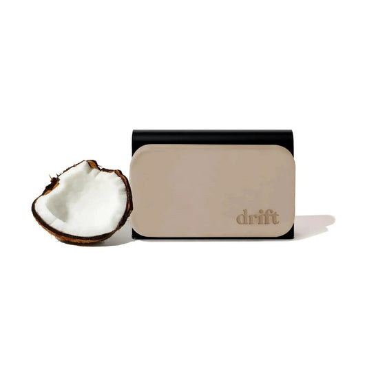 Stone Car Air Freshener With Metal Clip And Cabana Scent Starter Kit next to a coconut half.