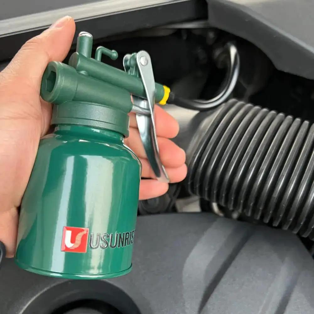 Hand holding Garage Ready Dual Spout Oiler Can 8oz Green Metal Pump With Flexible And Straight Spouts For Precision Lubrication