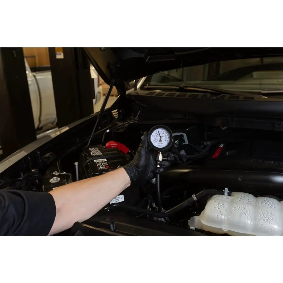 Person using Engine Compression Test Kit With 2.75in Gauge And Quick Disconnect Adapters on car engine
