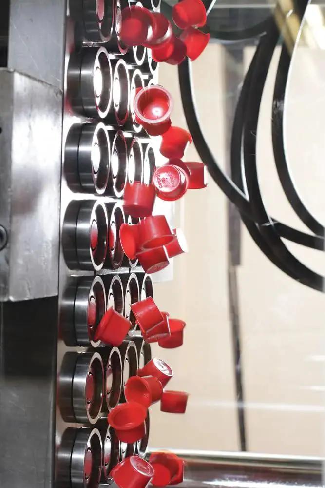 Red Tapered Cap and Plug Set for T Series LD-PE being used in manufacturing process to protect SAE fittings and hydraulic equipment.