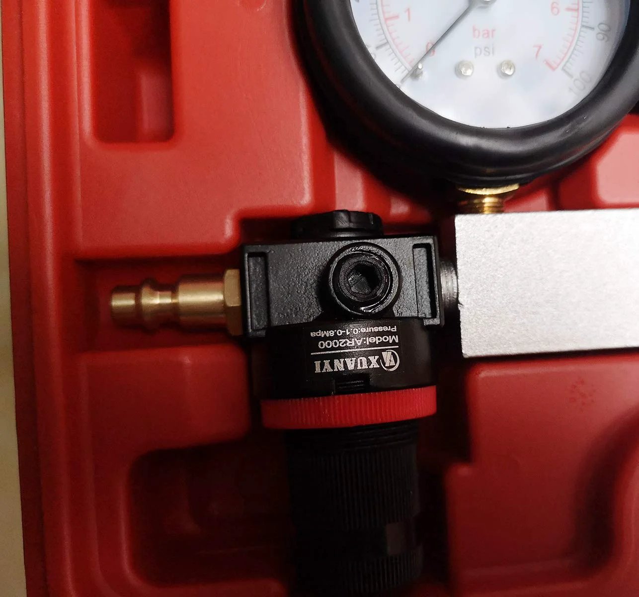 Close-up of Cylinder Leak Down Tester And Compression Test Kit with gauge and fitting, used for engine diagnostics.