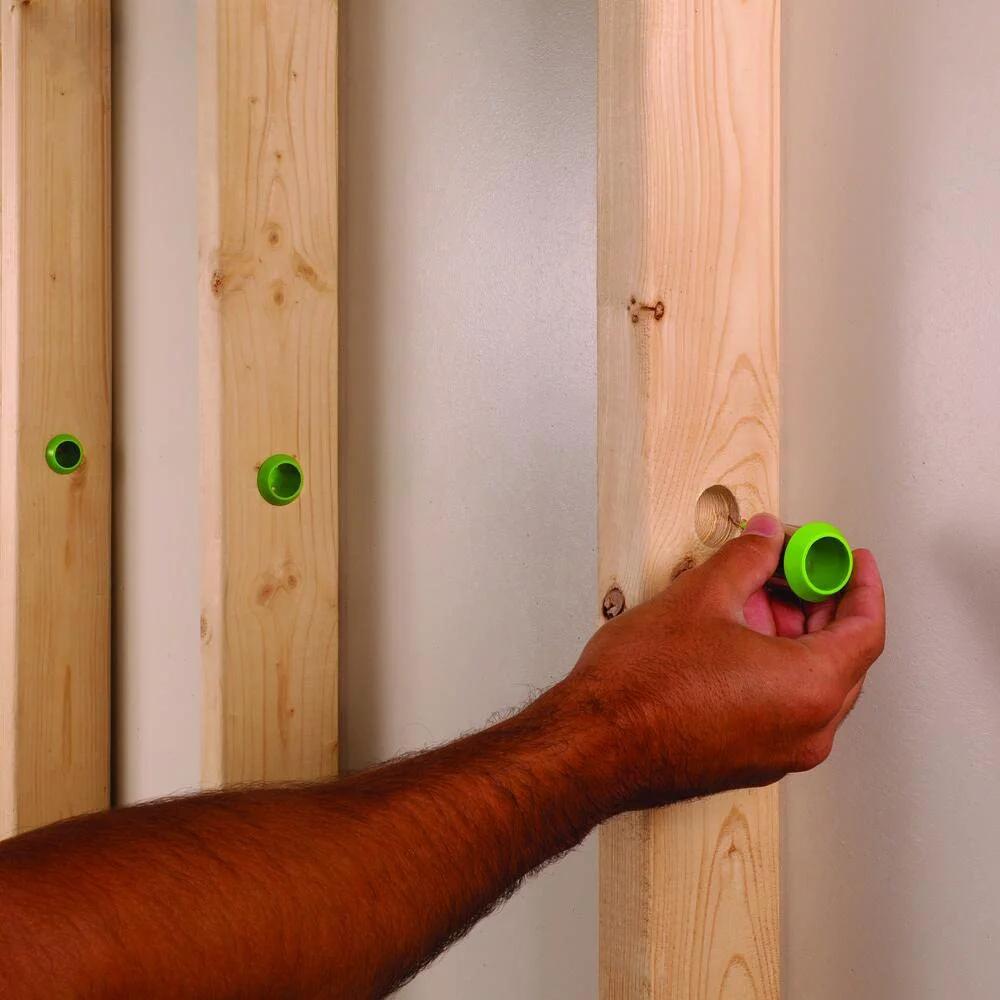 Person installing Stud Electrical Wire Protector 5 Pack for DIYers by EZ Guard 360 Degree Shield in wooden stud wall