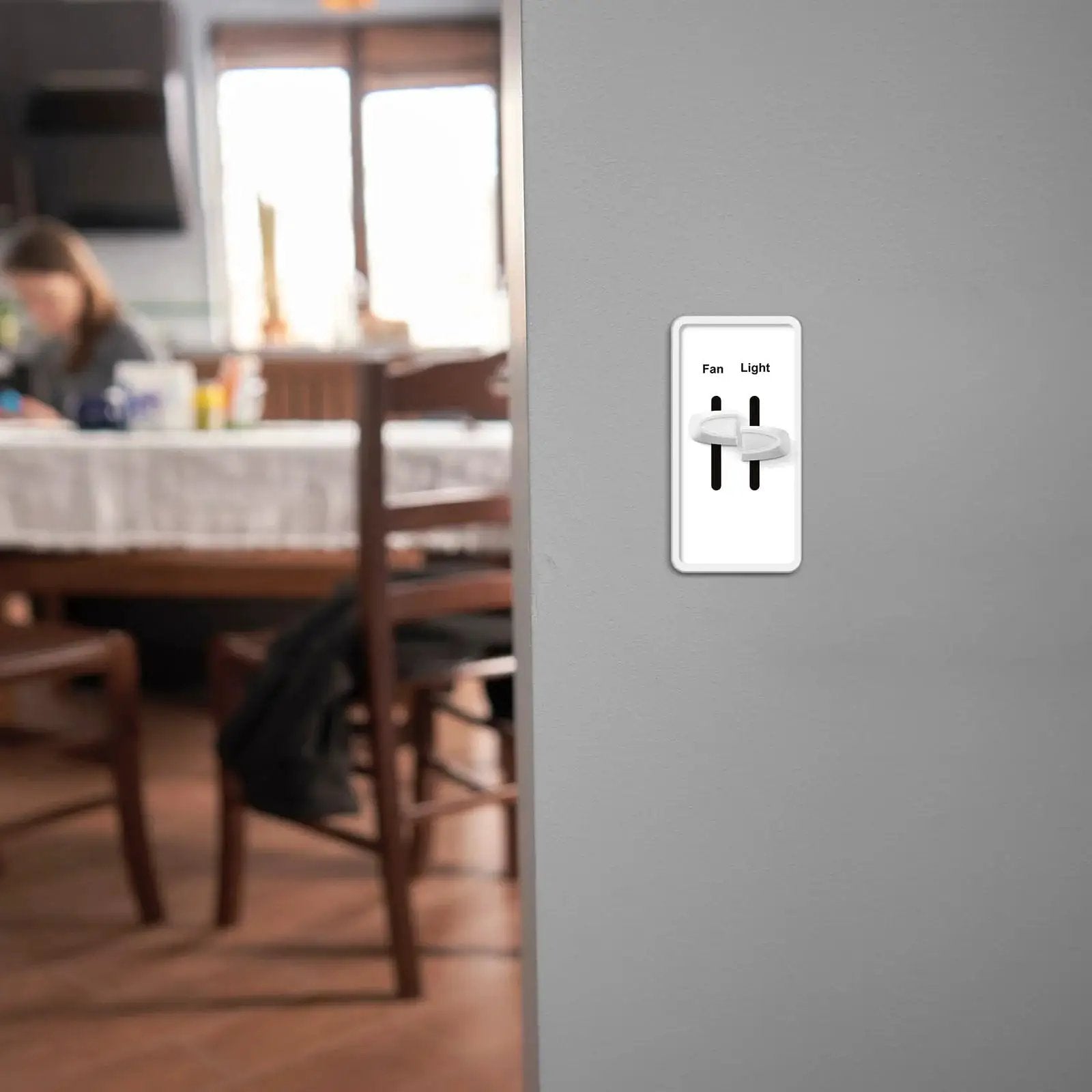 Installed two dimmer knob replacements for Lutron Skylark dual dimmer switches white on a wall in a dining area.