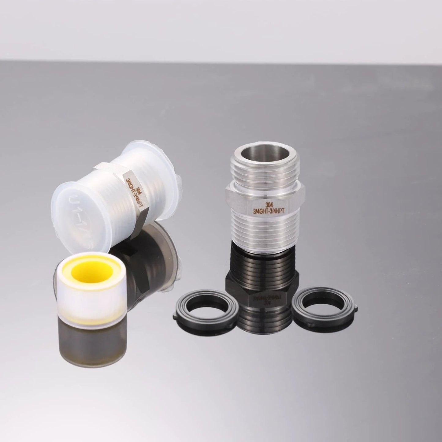 Three Quarter Inch GHT Male To Three Quarter Inch NPT Male Connector With One Half Inch NPT Female 304 Stainless Steel Garden Hose Fitting Adapter For Hose To Pipe Heavy Duty 2 Pack shown with washers and tape on reflective surface