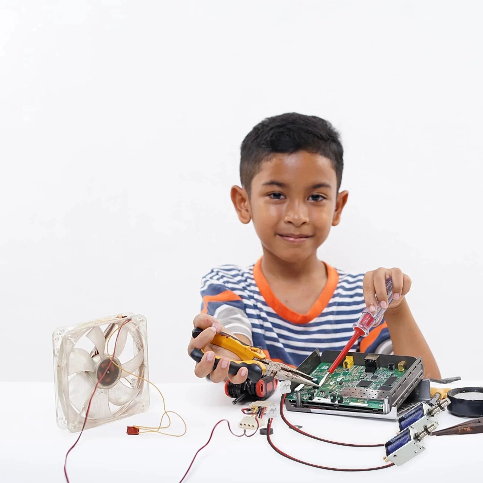 Child working on a DIY electronics project with a circuit board and mini fan.