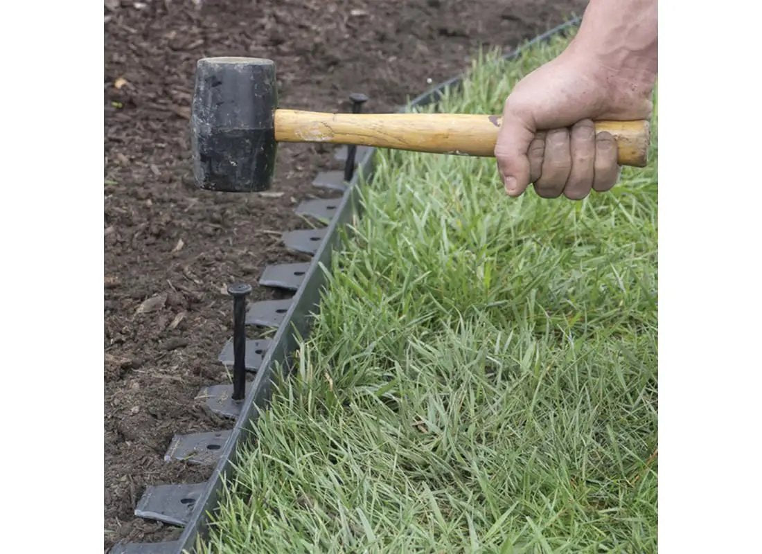 No Dig 8 Inch Nylon Spiral Landscape Edging Anchoring Spikes Pack Of 6 Black For Securing Edging And Landscape Fabric In Your Yard No Tools Needed Super Sturdy Weather Resistant Design By EasyFlex being installed with a rubber mallet