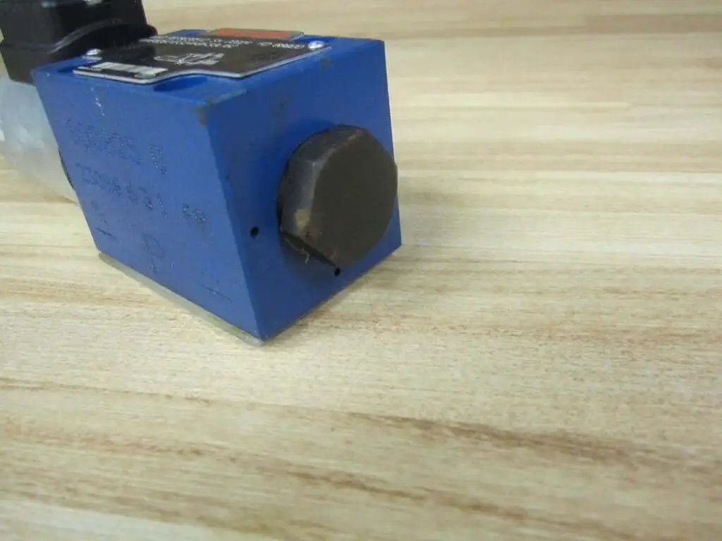 Close-up of Solenoid Directional Spool Valve 4WE6D62/EG24N9K33L/62 PN R978020512 Size 6 on wooden surface