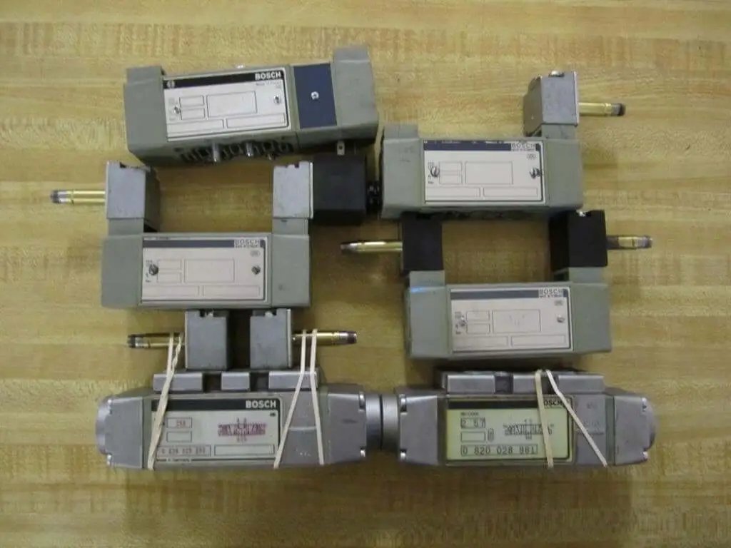 Hydraulic control valve pack 6-piece repair set for parts or refurbishment, showing six industrial valves on a wooden surface.
