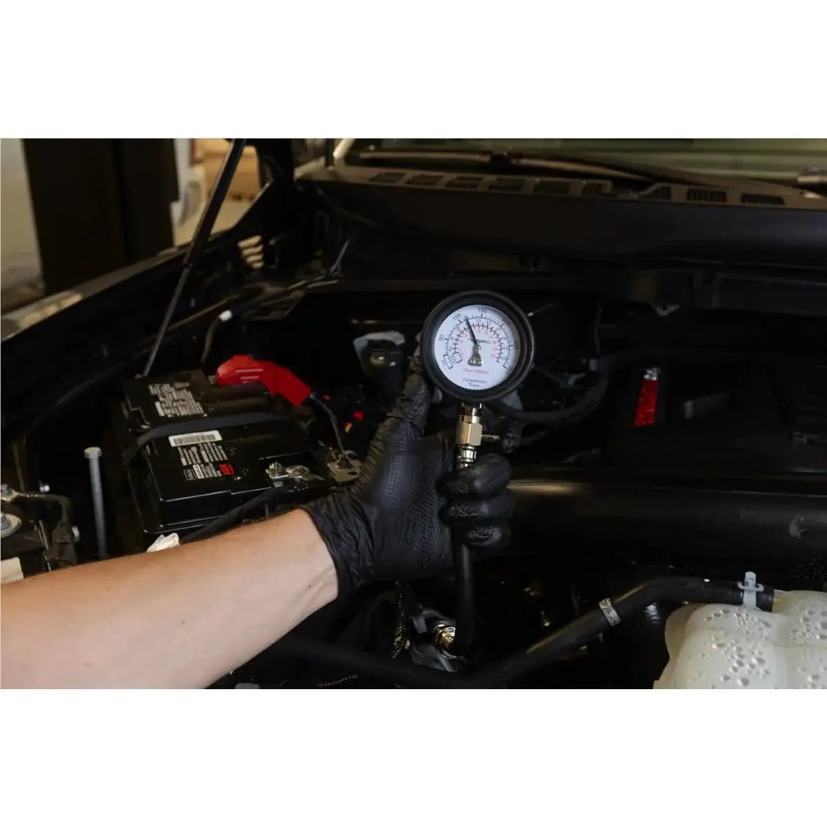 Engine Compression Test Kit With 2.75in Gauge And Quick Disconnect Adapters in use on car engine for diagnostic testing
