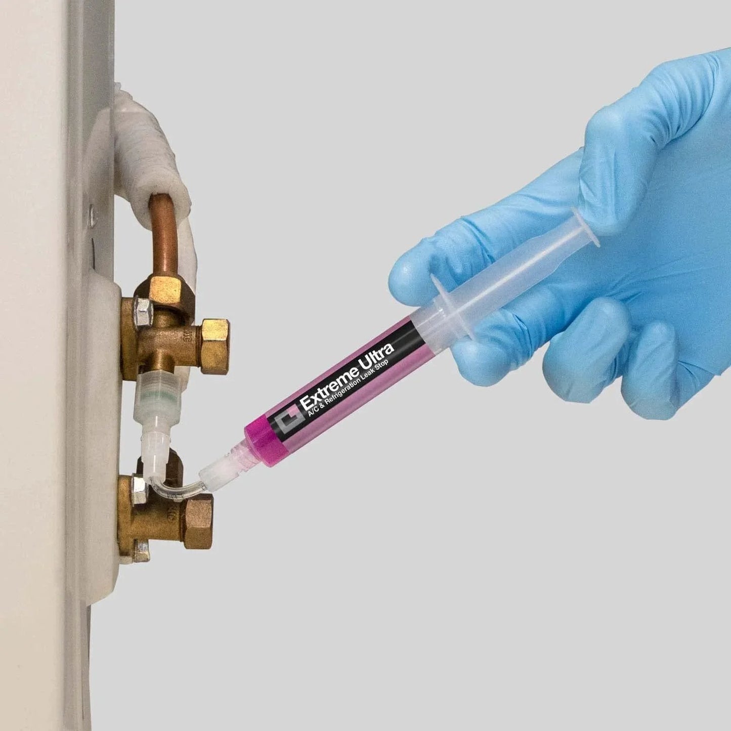 Extreme Ultra AC Leak Stop For HVAC R Systems Up To 6 Tons Works With All Refrigerants And Lubricants Polymer Free Formula Includes One Quarter SAE And Five Sixteenth SAE Adapters 0.2 Fl Oz Cartridge ERRECOM being applied to valve by hand.