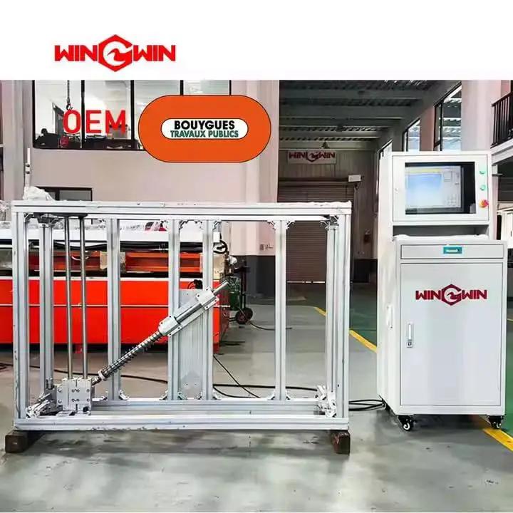 Testing equipment in a factory with control panel and frame, labeled with Win Win branding and OEM Bouygues Travaux Publics.