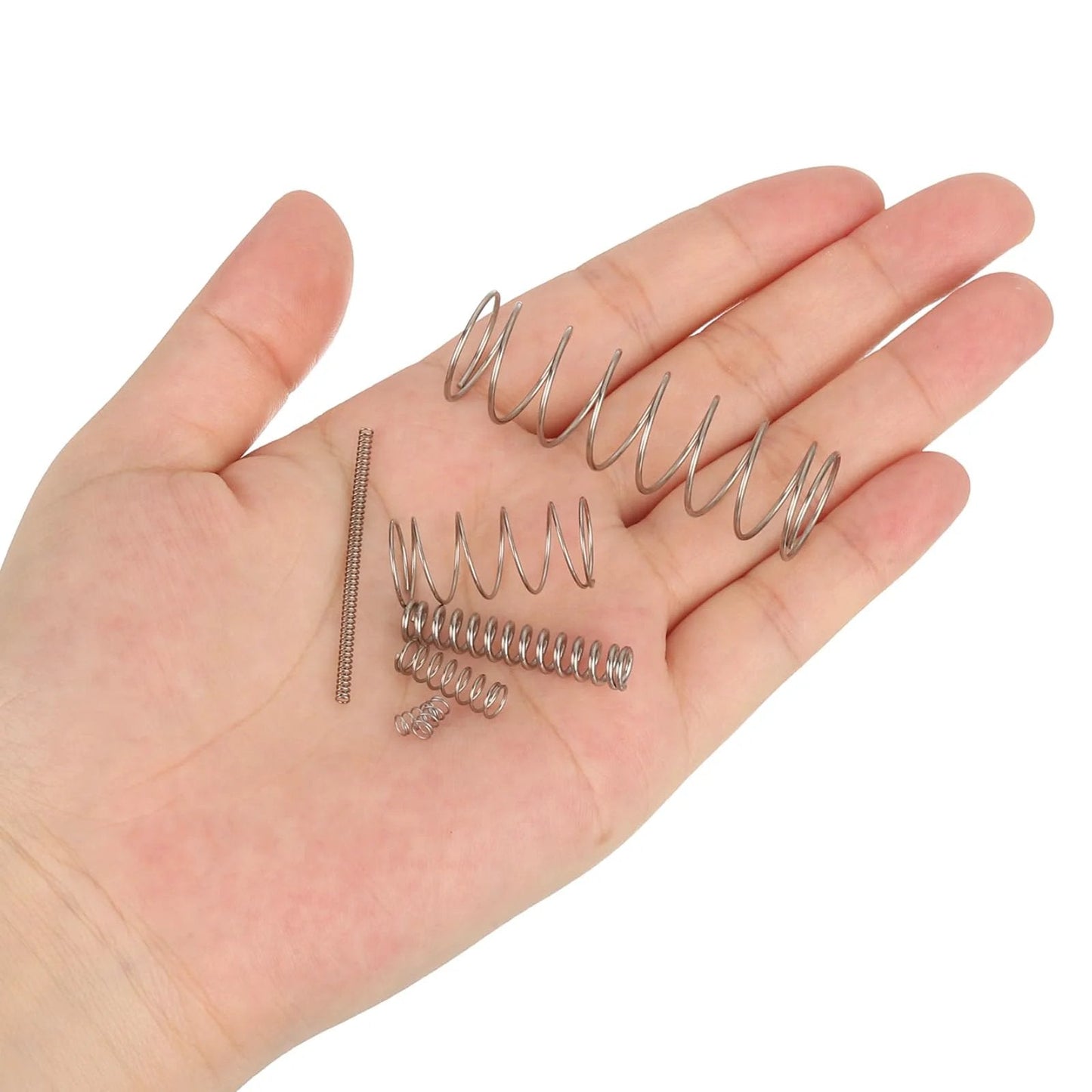 Various sizes of compression springs made of 304 stainless steel in a hand, showcasing silver tone and material quality.