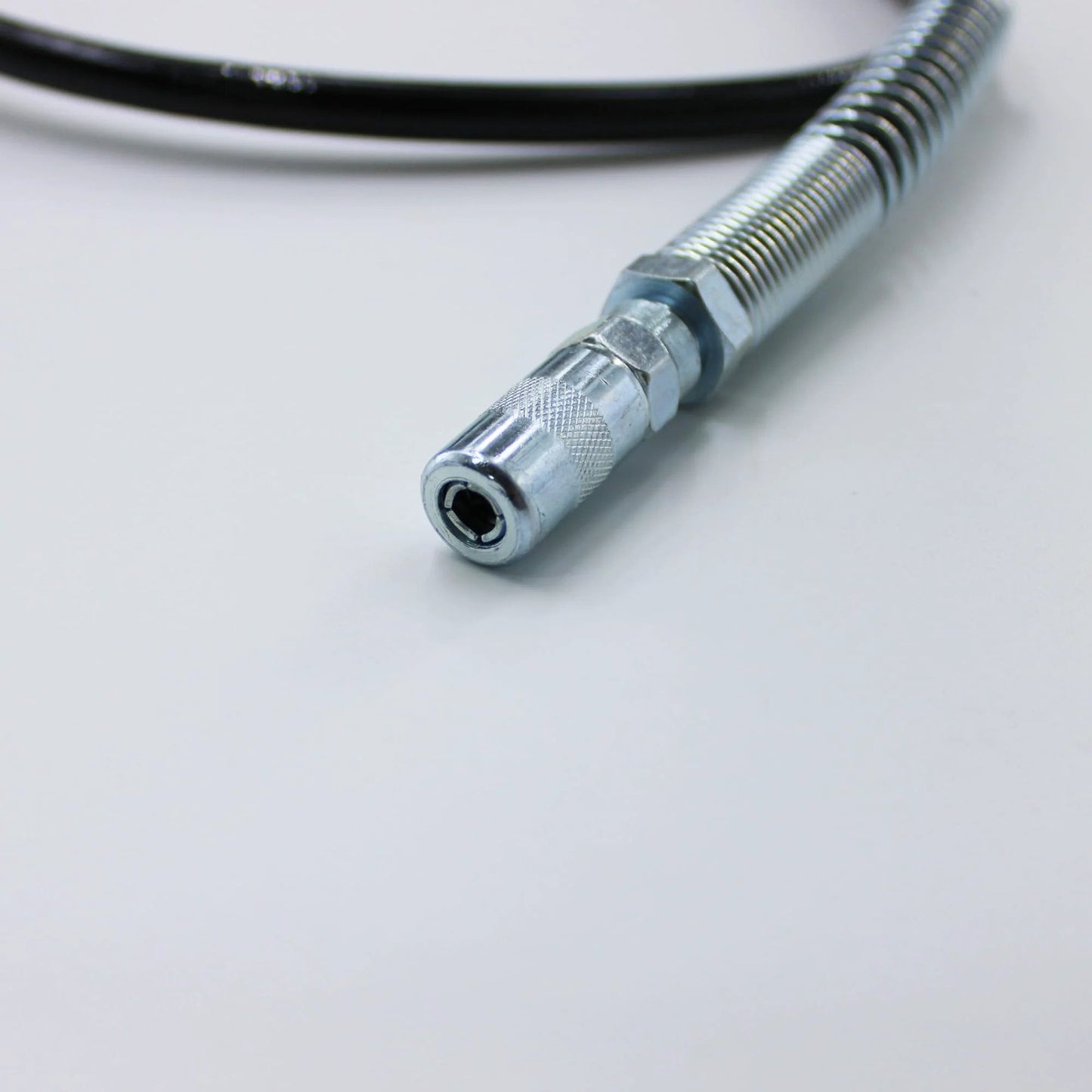 Close-up of a metal tip on a 48-inch grease gun hose replacement for Milwaukee M18 and M12, pro grade flexible 49-16-2647.