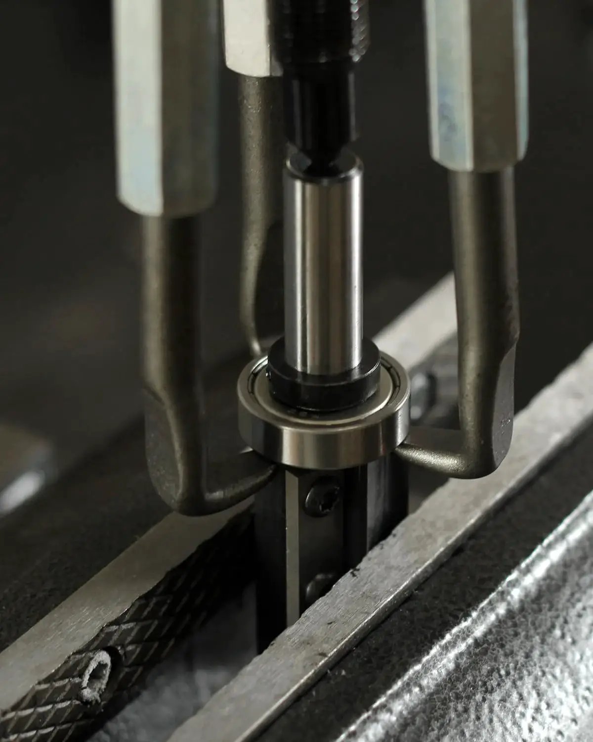 Inner Hole Bearing Puller Set With Three Jaw Design extracting a bearing from a recessed area, showing steel collet gripping mechanism in use.