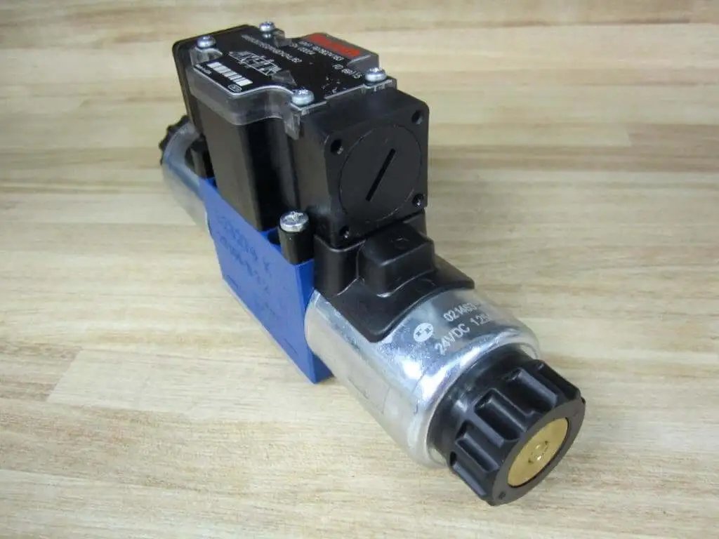 Solenoid directional valve R978024163 4WE6Q62/EG24N9DK24L/62 single unit with 24VDC coil and 4-pin male connector on wooden surface