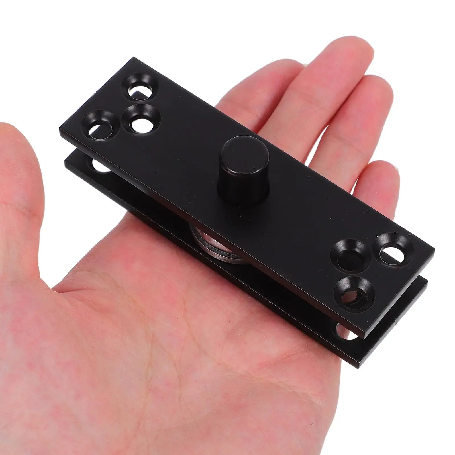 Beefy Hidden Door Hinge 360 Degree Stainless Steel Concealed Pivot for cabinets and bookcases, held in hand, black finish.