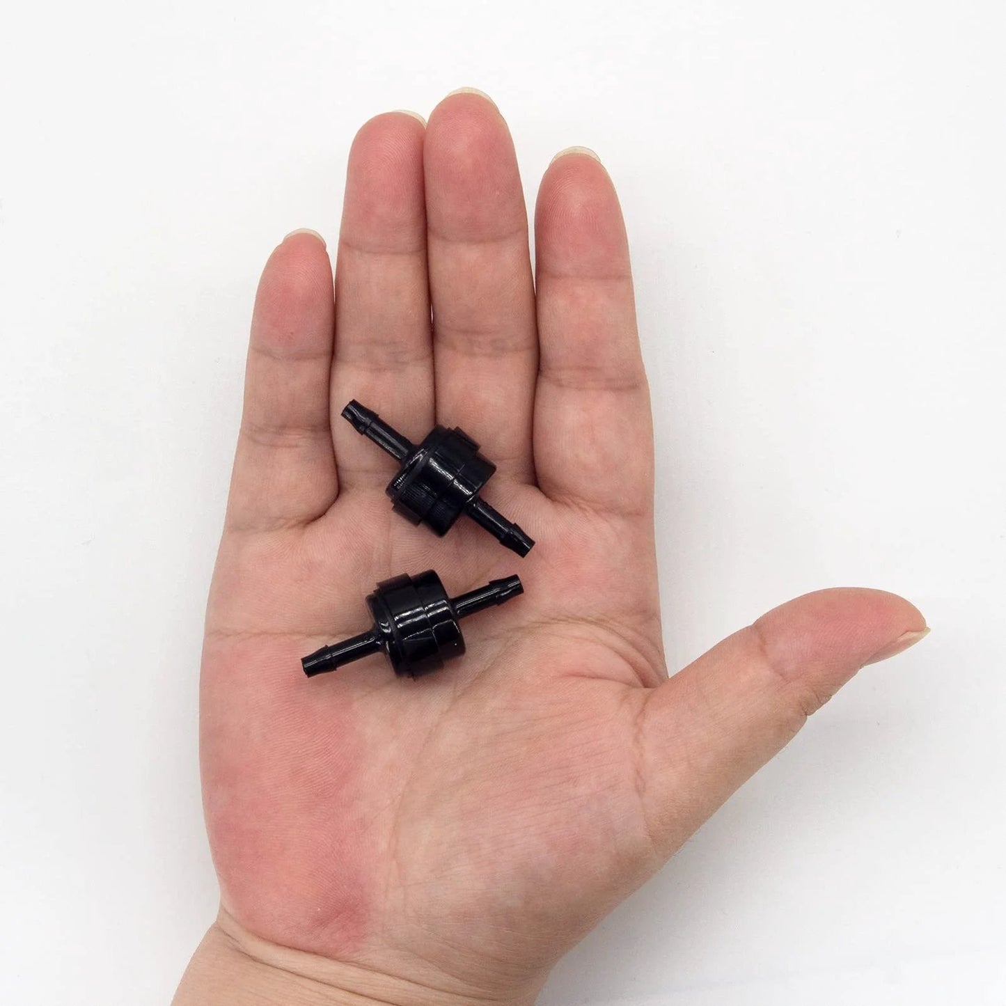 Person holding two black Automotive PA66 Spring Check Valves For High Temp And Corrosion Resistance, fits various hose sizes