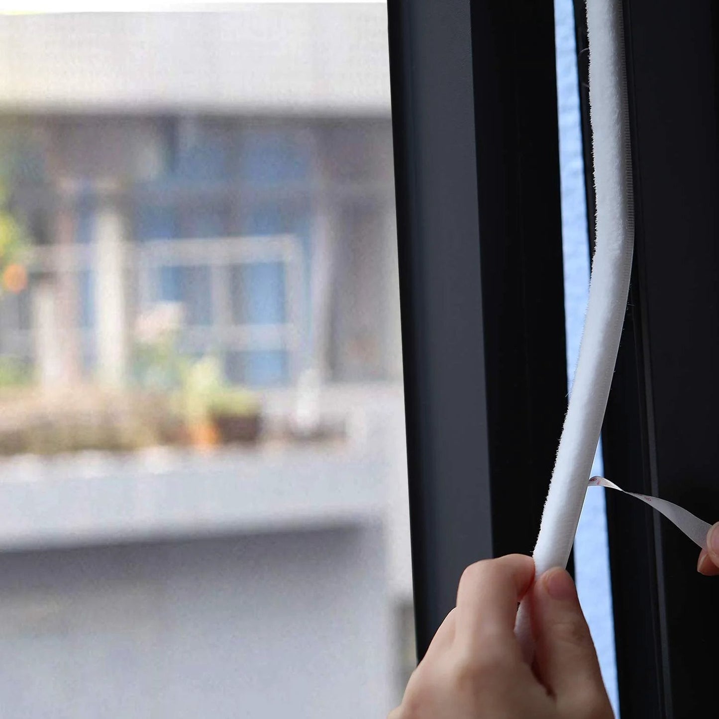 Person applying Fuzzy Brush Weatherstripping For Windows And Doors, Self Adhesive Felt Seal, 0.34375 Inch By 0.34375 Inch, 16 Ft Long