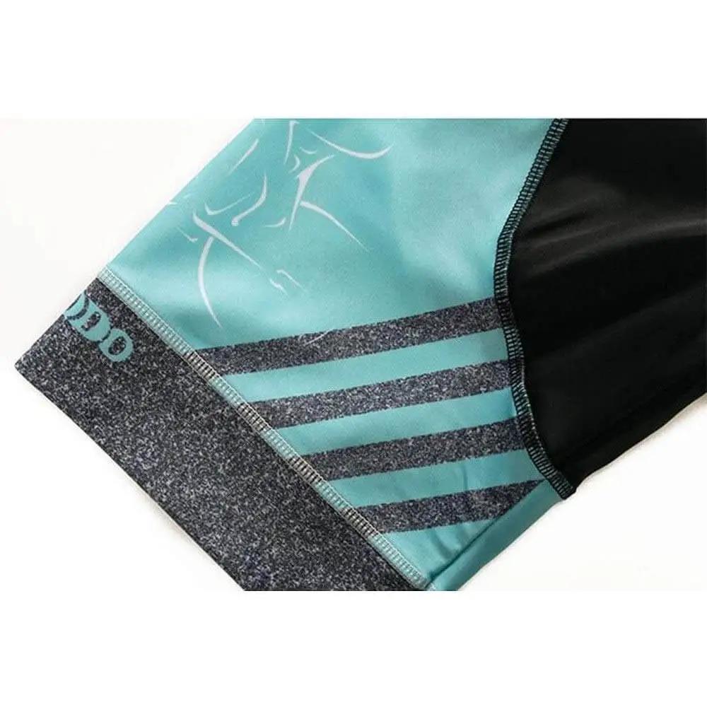 Close-up of teal and black athletic shorts with stripe design and logo on the hem