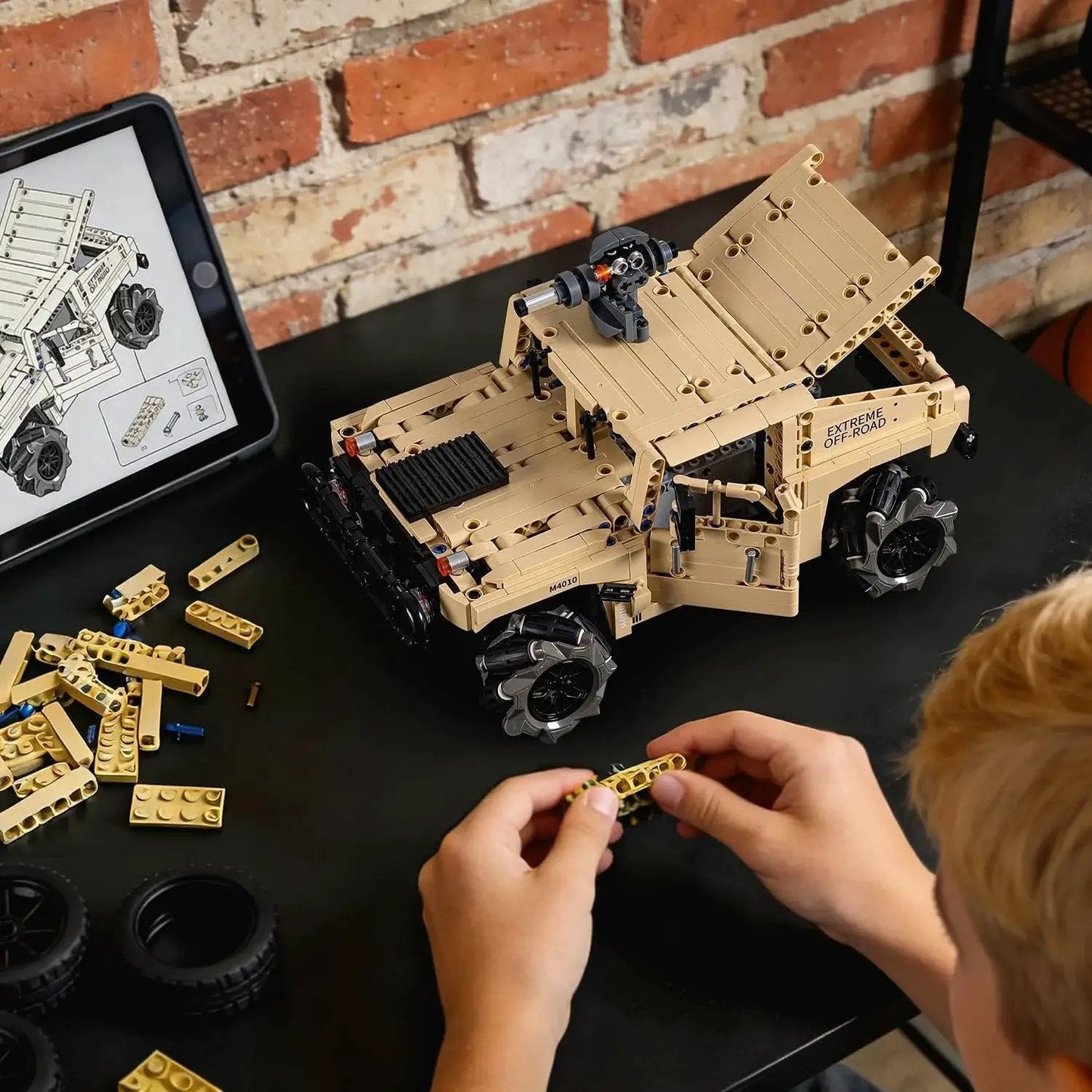 Off Road Hummer Armor RC Car Kit With 804 Pieces For A Technic Style Build on desk, child assembling with instructions