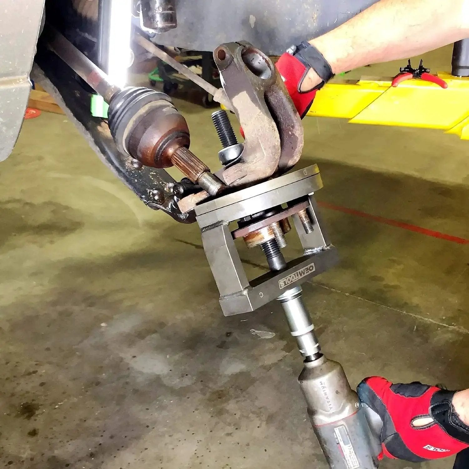 Mechanic using Master Wheel Bearing Removal Tool And Installer Kit with self-centering design on vehicle hub.