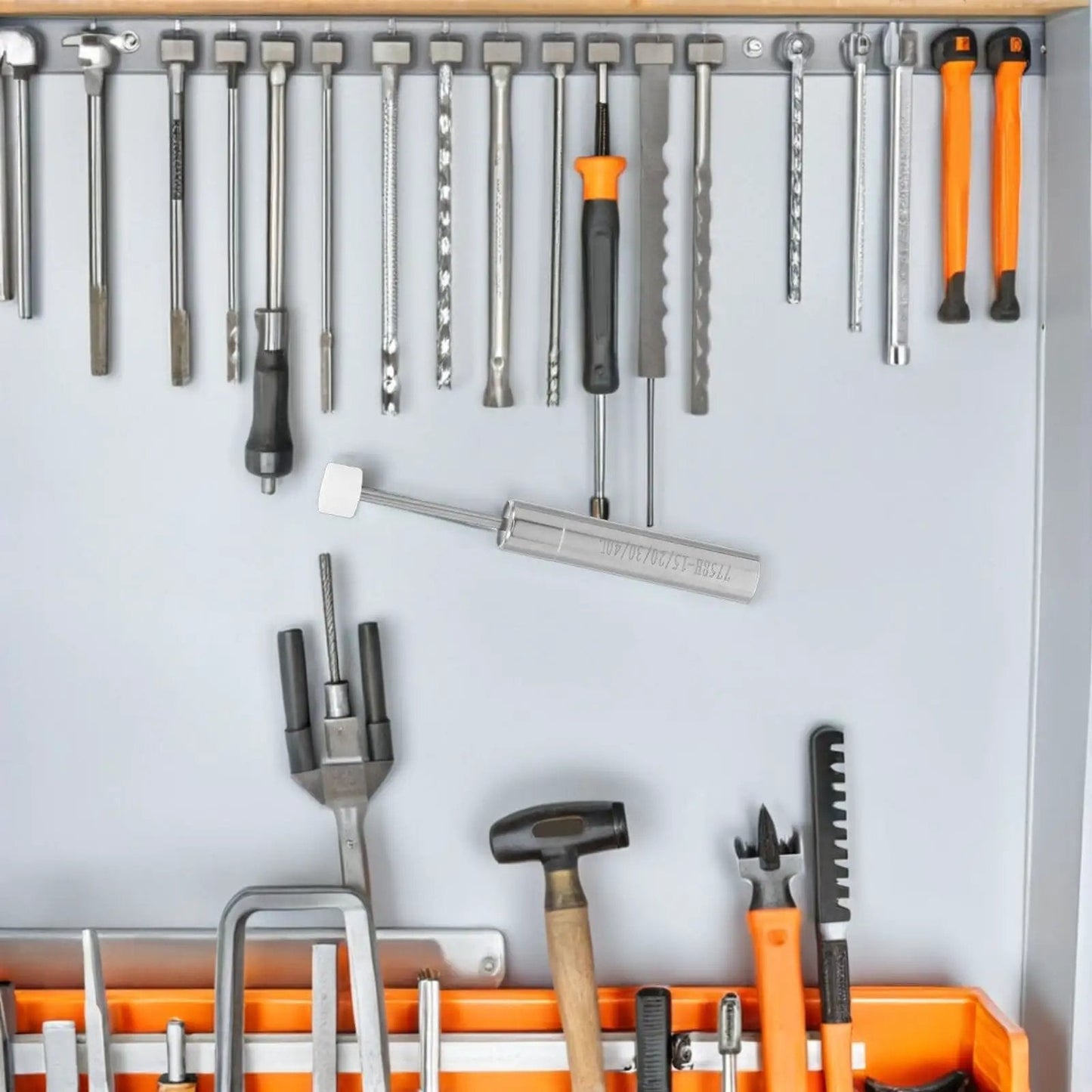 Assorted hand tools including hammers and screwdrivers organized in a toolbox with a labeled hydraulic piston tool.