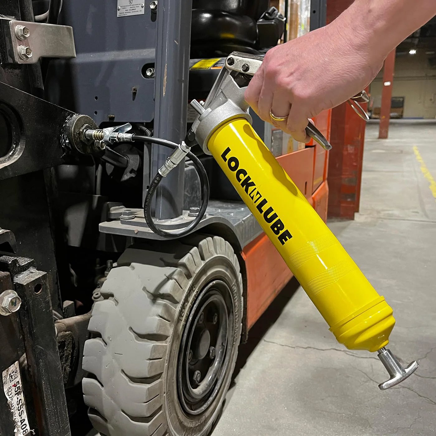 Using Premium Pistol-Grip Grease Gun With LockNLube Coupler, 20 Inch Hose And Inline Swivel on industrial equipment