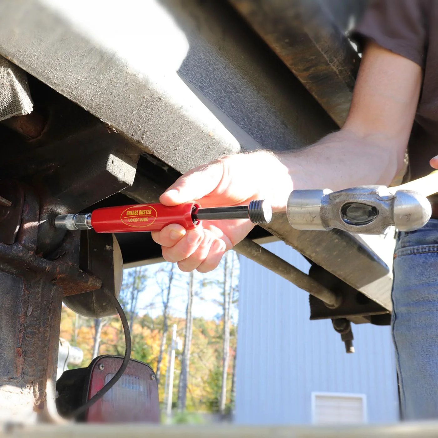 Person using Grease Buster The Original Grease Flushing Tool For Fittings Pins Shafts And Joints Uses Penetrating Oil And Hydraulic Pressure To Clean Dried Grease Made In USA By LockNLube on machinery