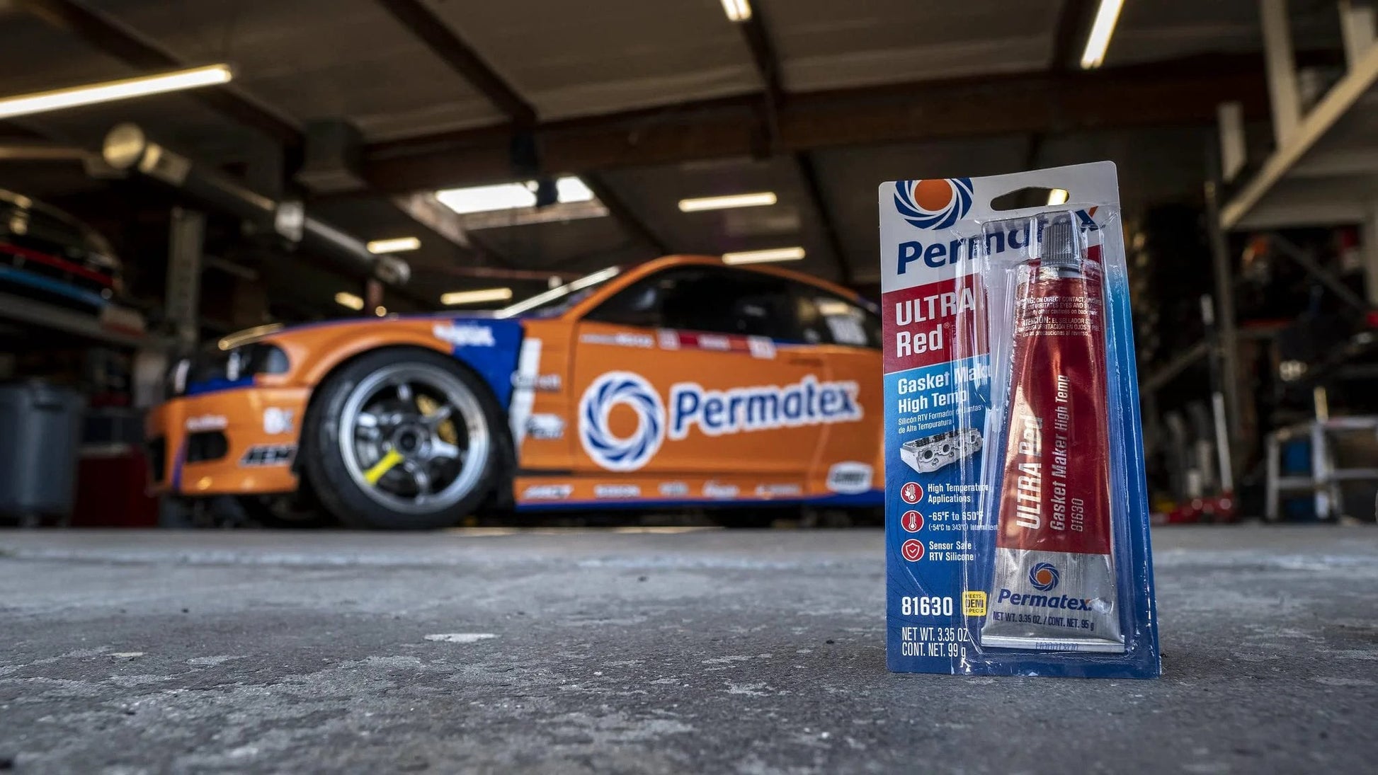 Ultra Red High Temperature Gasket Maker For Automotive Gaskets 3 Oz By Permatex displayed in a garage with race car