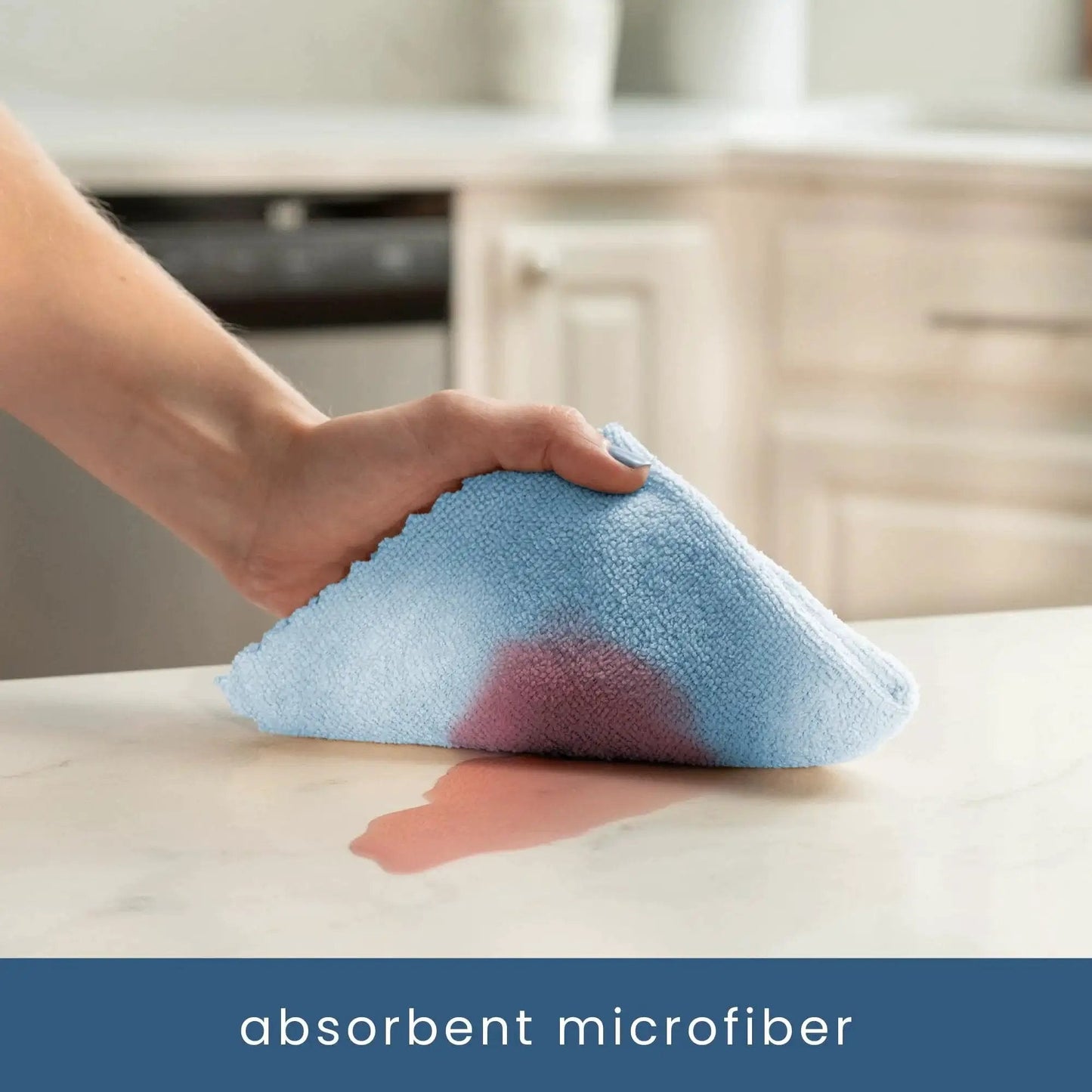 Hand using 50 Pack Microfiber Towels 11.8x11.8 In Lint-Free Reusable For Home And Car to clean a spill on countertop