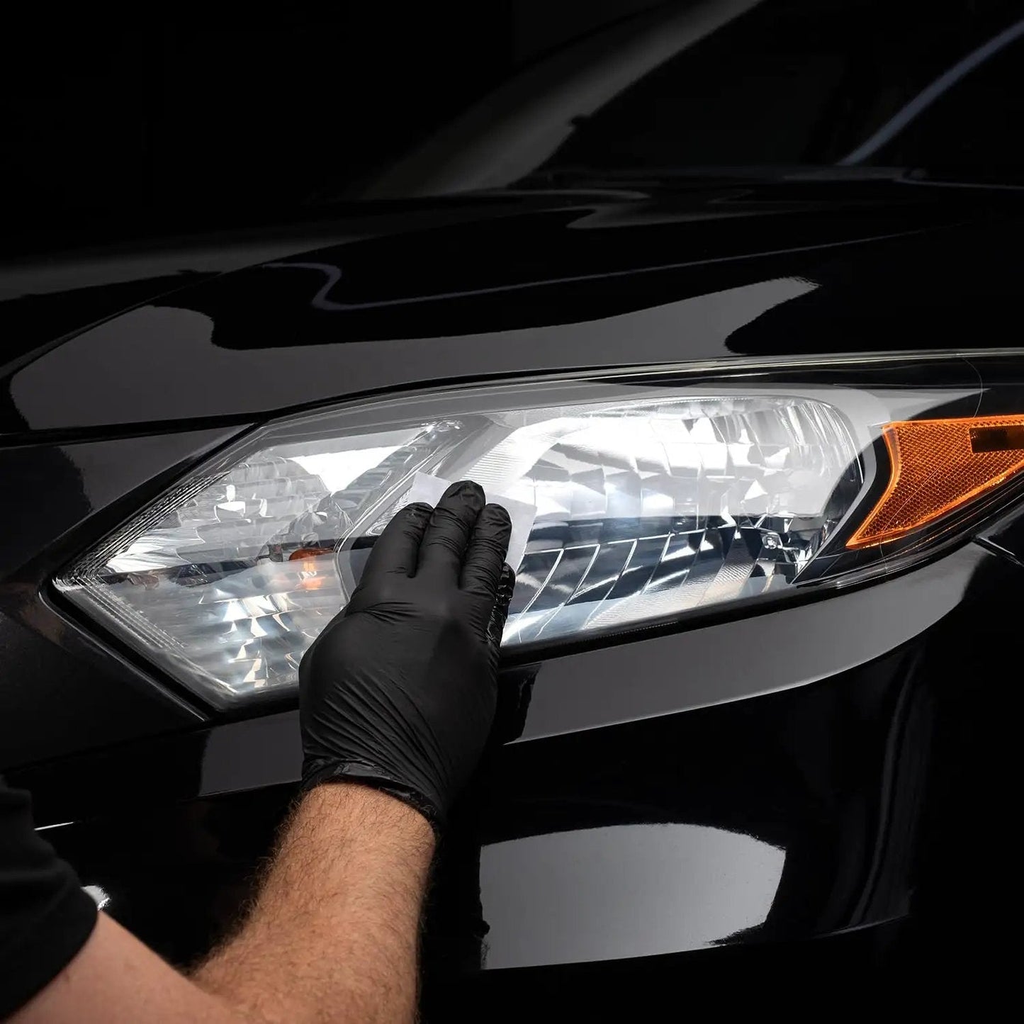 Close-up of Long Lasting Ceramic Headlight Restoration Kit application on car headlight for clarity.