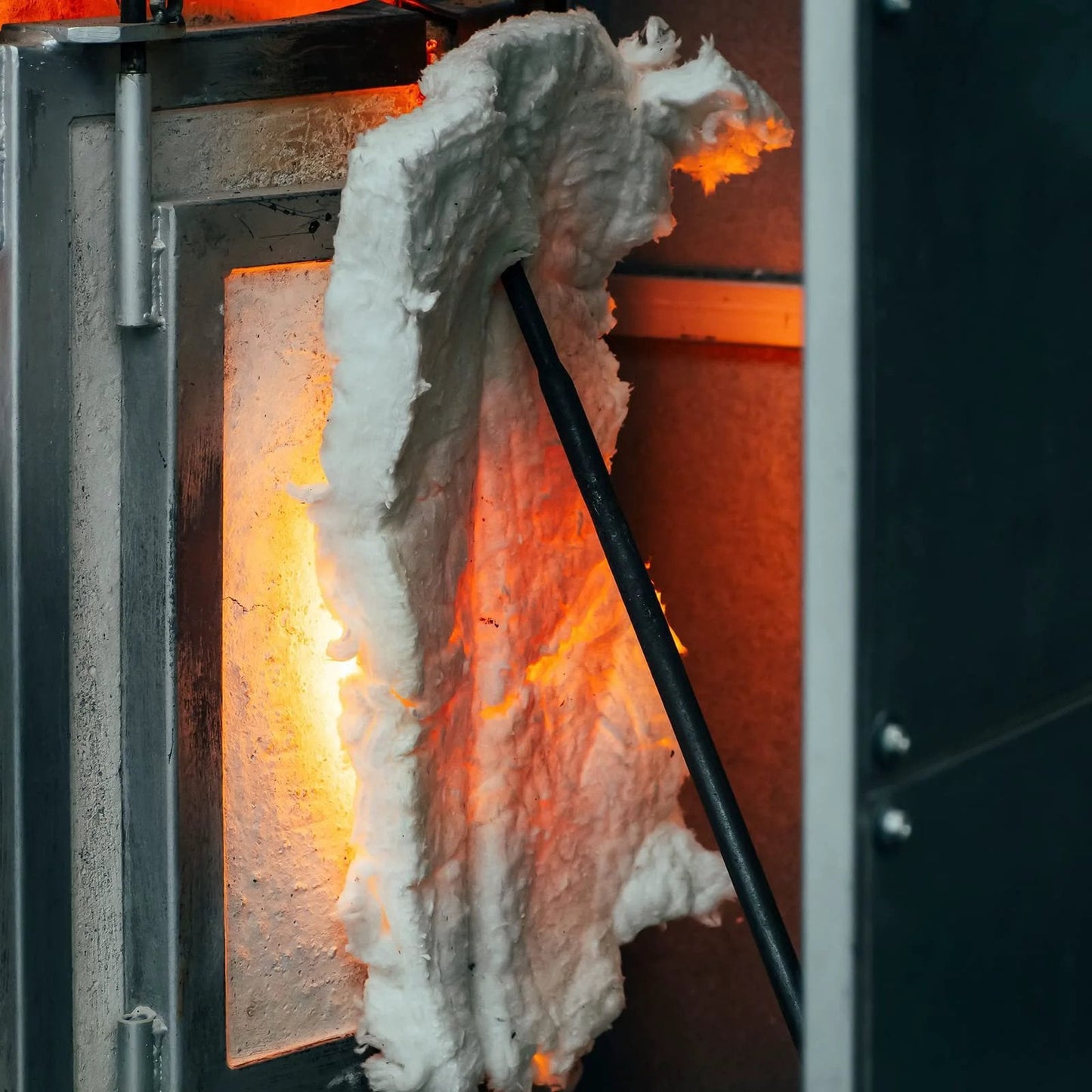 2 Pack Ceramic Fiber Insulation Blanket High Density 2400F Fireproof For Furnace Stoves Kilns Forges Fireplaces 24 X 12 X 1 Inches White Heavy Duty Heat Shielding For DIY Projects And Industrial Use being used in a high-temperature furnace, shown from the front with glowing heat in the background.