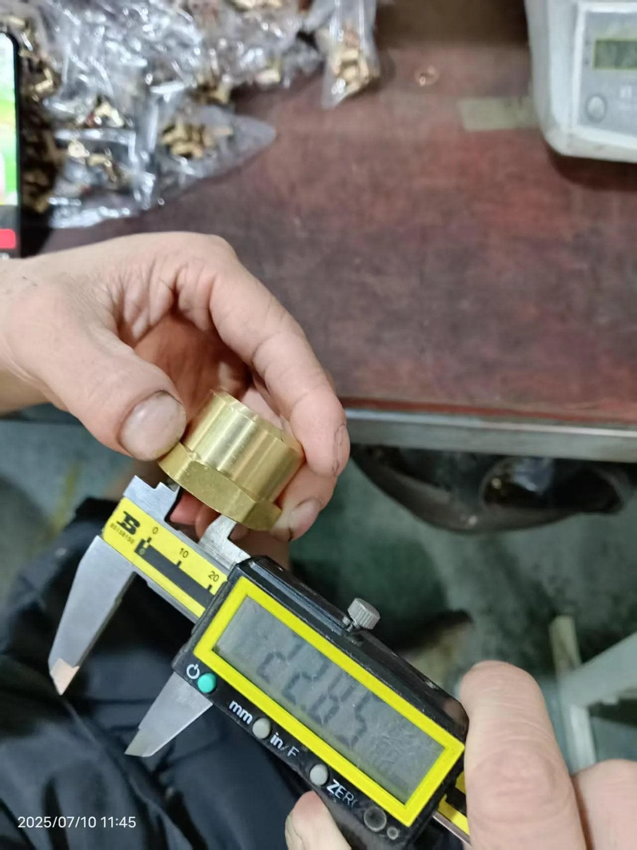 Close-up of Three Quarter Inch NPT Female Brass Pipe Cap Hex Head Fitting being measured for accuracy