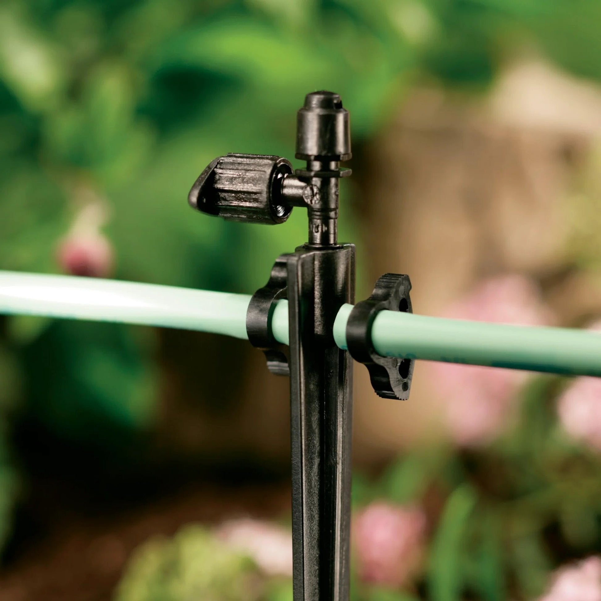 Secure One Quarter Inch Drip Tubing High Pressure Clamps Black 10 Pack installed on outdoor irrigation tubing.