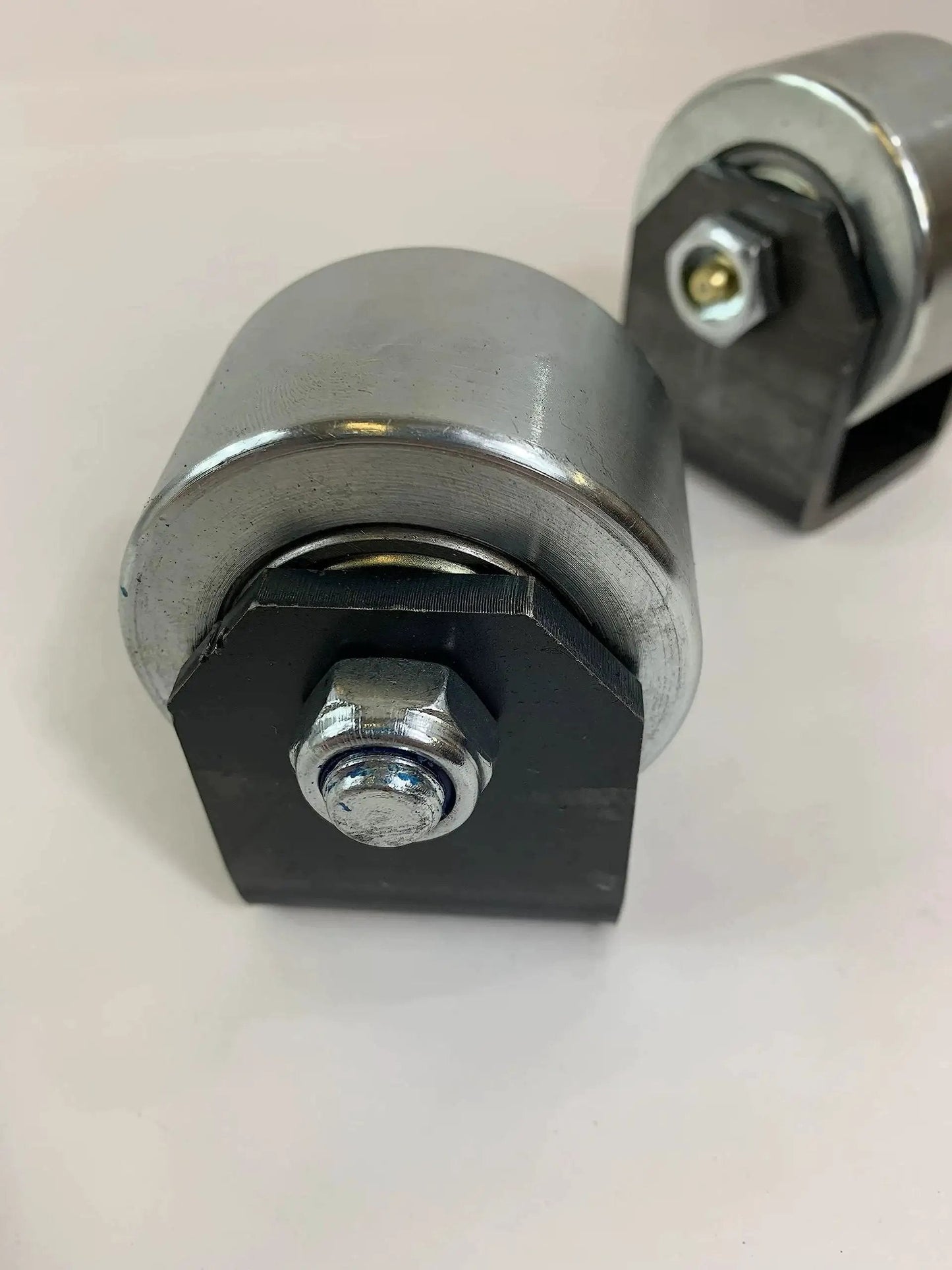 Set Of 2 Weld On Trailer Tail Drag Casters With Solid Steel Rollers And Greasable Axle 1.5 Inch Wide For Motorhomes RVs 5th Wheels And Campers Helps Trailer Roll Over Concrete And Prevent Hanging On Inclines Curbs Or Steep Driveways close-up view