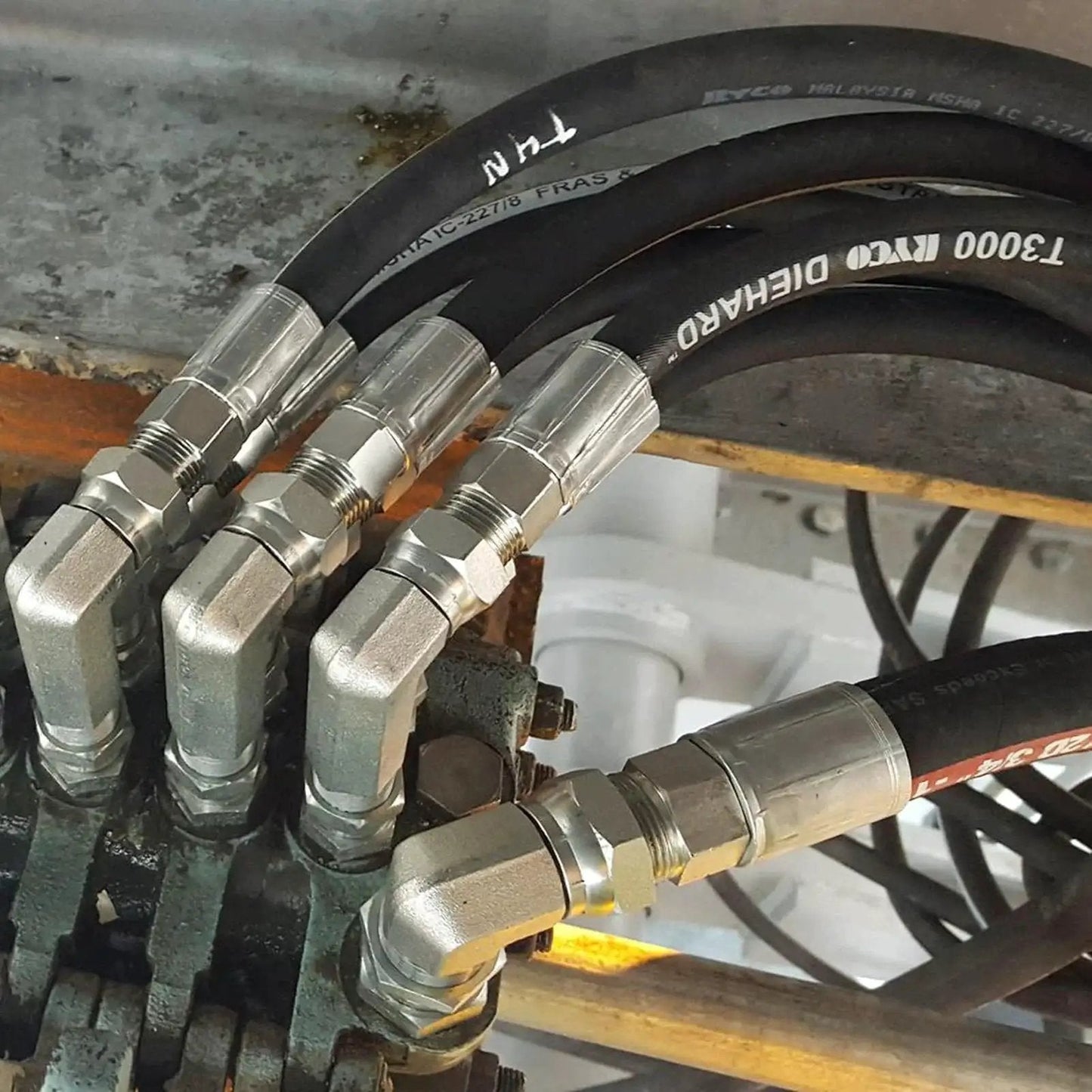 12 Pack 1/2 Inch Hose To 1/2 Inch NPTF Male Hydraulic Crimp Fittings in heavy duty carbon steel installed on machinery