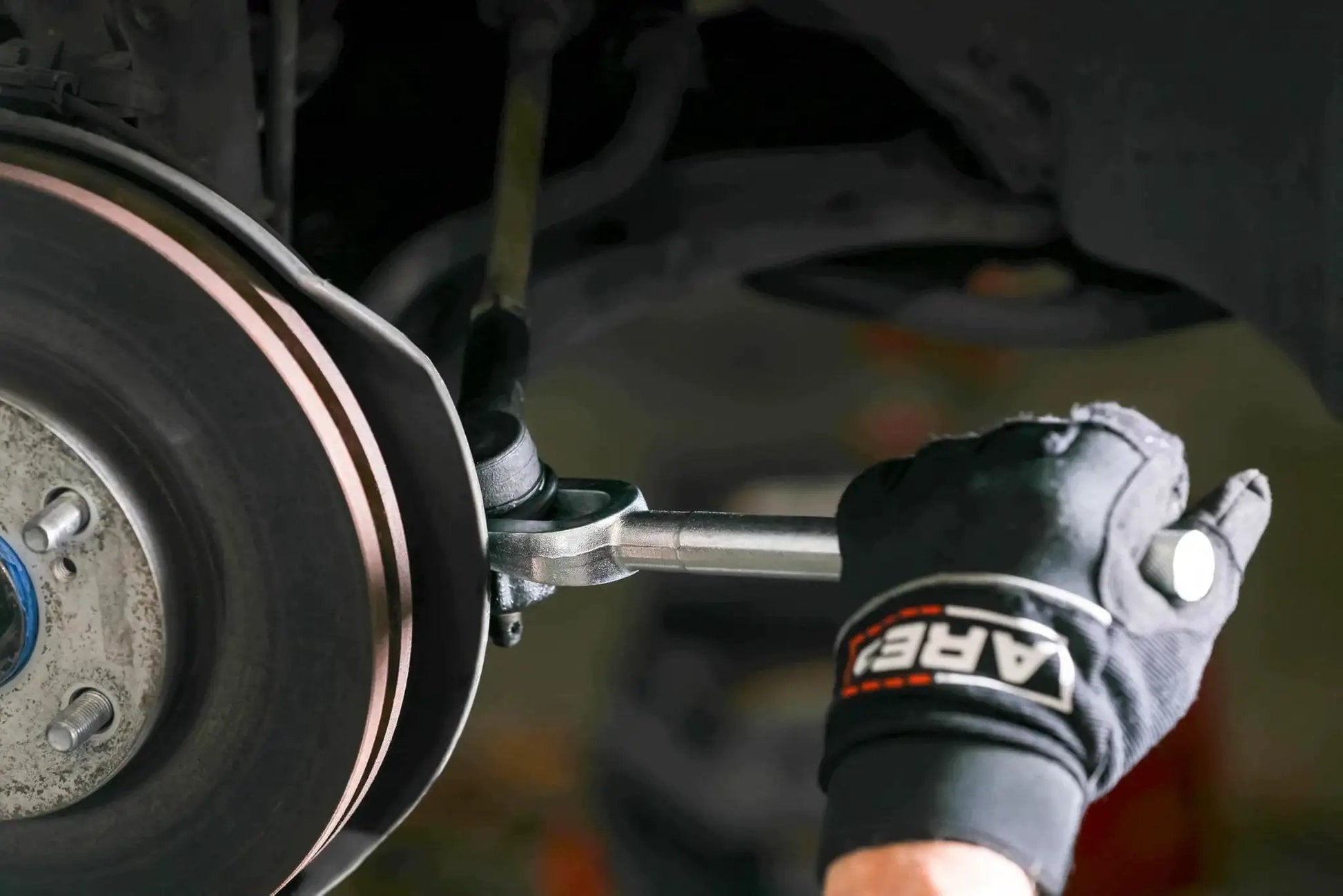 Mechanic using Ball Joint Separator Pickle Fork 15/16 Inch Tapered Fork With Knurled Handle on vehicle suspension