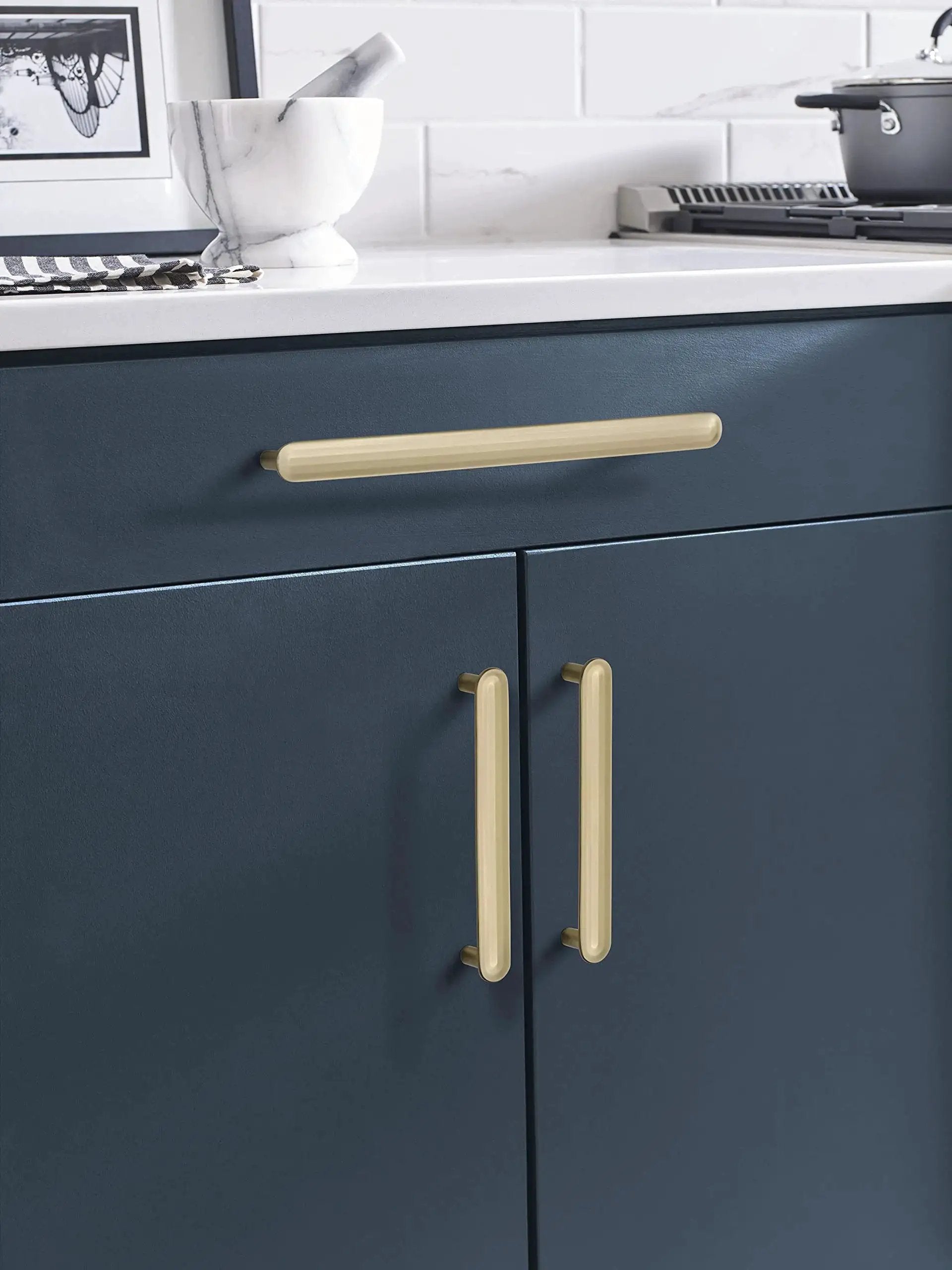 Golden Champagne Cabinet Pull Concentric Modern Style Five And One Sixteenth Inch Center To Center installed on blue kitchen cabinets.